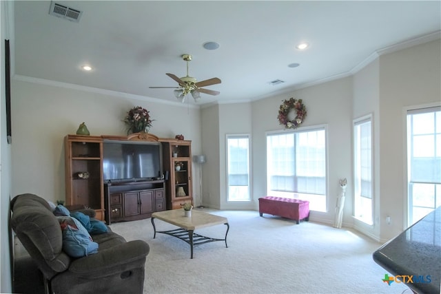 carpeted living room featuring ceiling fan and crown molding