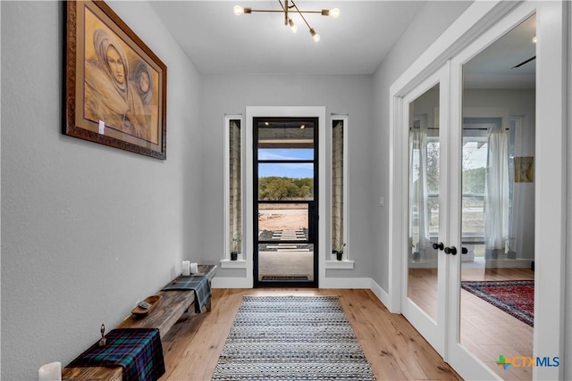 123 Wandering Oak Cir, Burnet, TX 78611 - entryway with french doors, a chandelier, light wood-type flooring, and baseboards