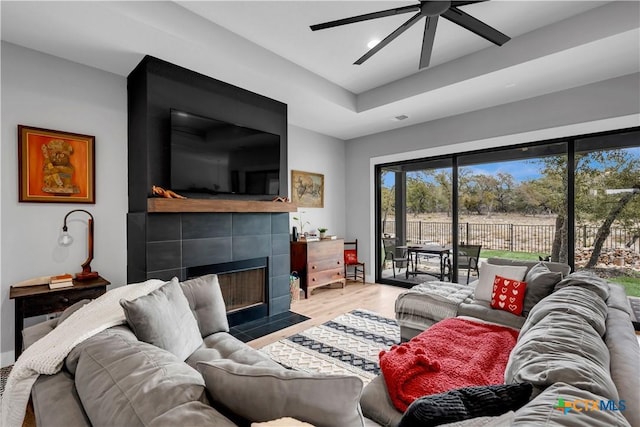 123 Wandering Oak Cir, Burnet, TX 78611 - living room featuring a tiled fireplace, ceiling fan, recessed lighting, and light wood-style flooring