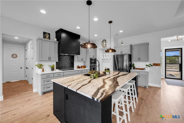 123 Wandering Oak Cir, Burnet, TX 78611 - kitchen with freestanding refrigerator, a sink, light wood-type flooring, decorative backsplash, and recessed lighting