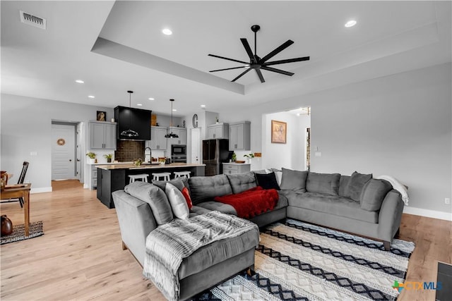 123 Wandering Oak Cir, Burnet, TX 78611 - living area featuring a ceiling fan, a raised ceiling, light wood-style floors, recessed lighting, and baseboards