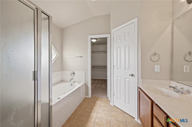 bathroom featuring lofted ceiling, a garden tub, tile patterned flooring, vanity, and a shower stall