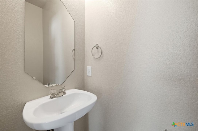 bathroom with a sink and a textured wall