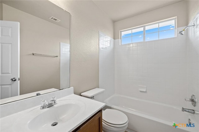 full bathroom featuring bathing tub / shower combination, visible vents, a textured wall, toilet, and vanity