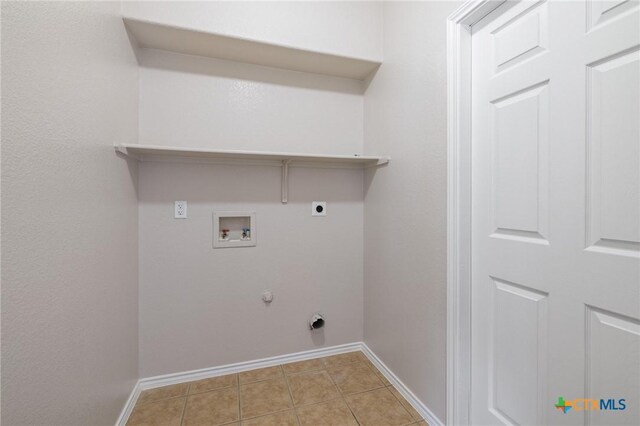 clothes washing area with laundry area, baseboards, gas dryer hookup, hookup for a washing machine, and hookup for an electric dryer