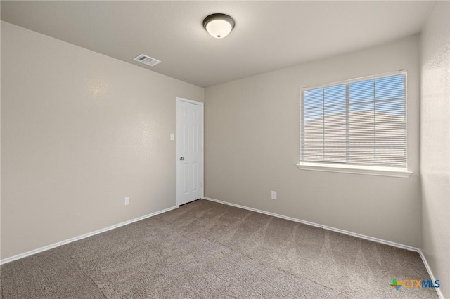 carpeted empty room featuring visible vents and baseboards