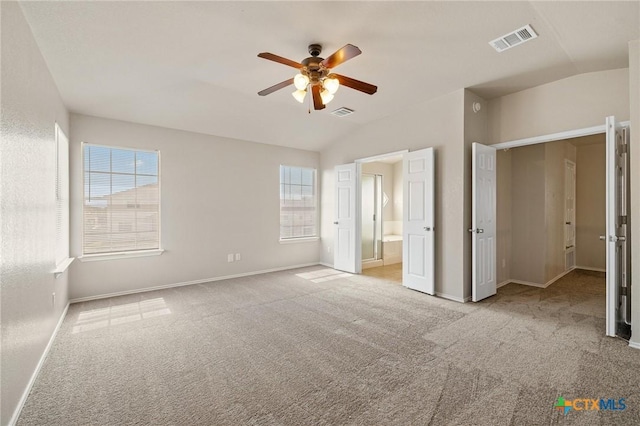 unfurnished bedroom featuring lofted ceiling, carpet, visible vents, and baseboards