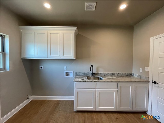 laundry room featuring hookup for an electric dryer, washer hookup, a sink, baseboards, and cabinet space