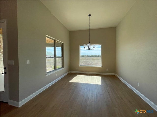 unfurnished dining area with an inviting chandelier, dark wood finished floors, and baseboards