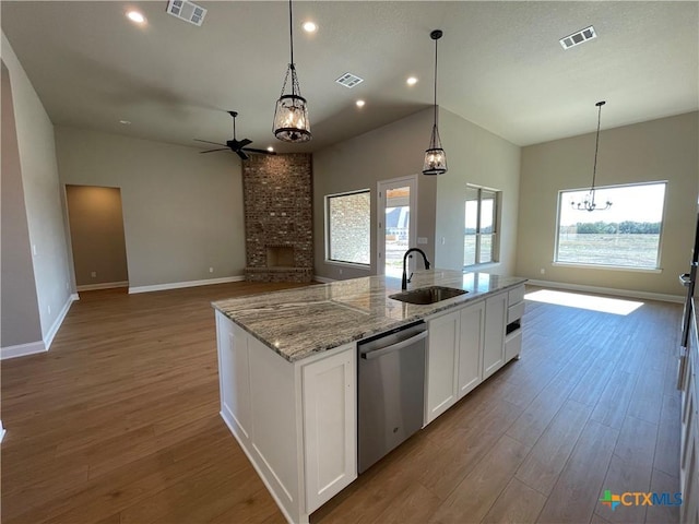 kitchen featuring a sink, visible vents, dishwasher, and wood finished floors