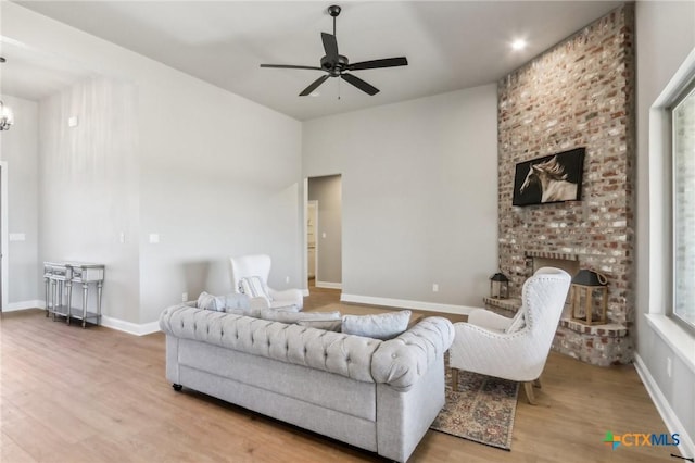 4007 Aerie St, Salado, TX 76571 - living area featuring wood finished floors, a fireplace, ceiling fan, and a chandelier