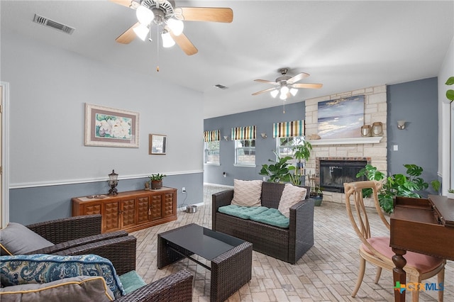 living area featuring visible vents, a ceiling fan, brick floor, and a fireplace