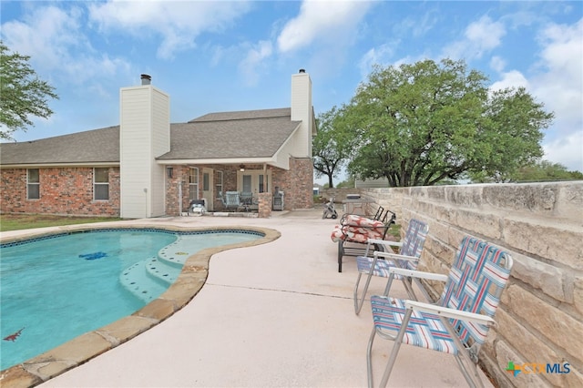 outdoor pool with a patio area