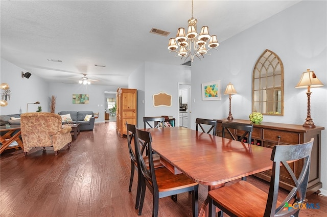 dining room featuring ceiling fan with notable chandelier, visible vents, and dark wood-type flooring