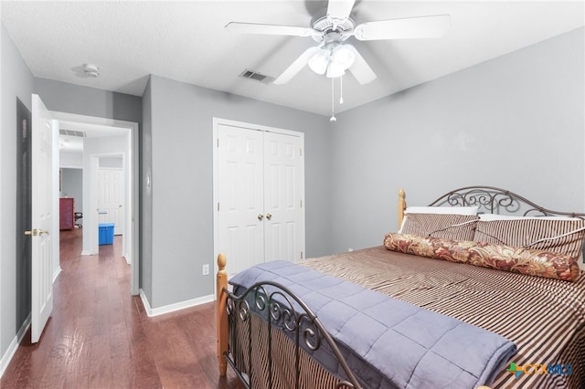 bedroom with visible vents, ceiling fan, dark wood-style floors, a closet, and baseboards