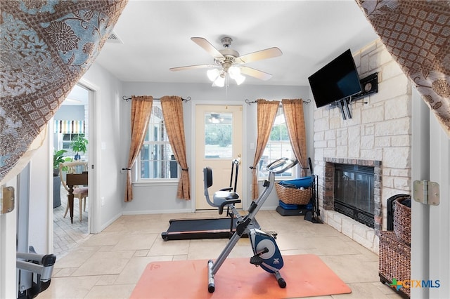 workout room featuring baseboards, ceiling fan, and a fireplace
