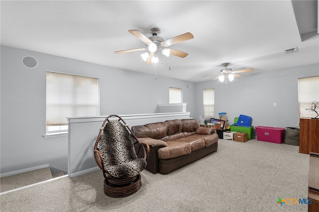 living room with baseboards, carpet flooring, ceiling fan, and visible vents