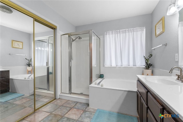 full bath with a shower stall, vanity, and a bath