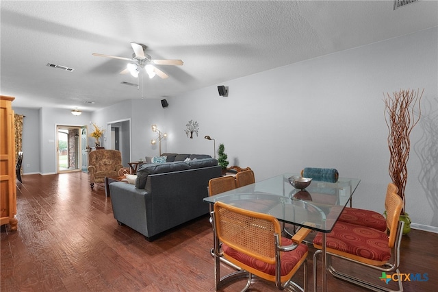 dining room with visible vents, a ceiling fan, a textured ceiling, and dark wood-style flooring