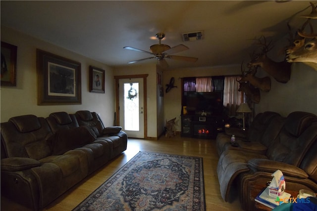 living room with light hardwood / wood-style floors and ceiling fan