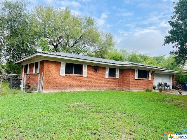 rear view of house with a garage and a lawn