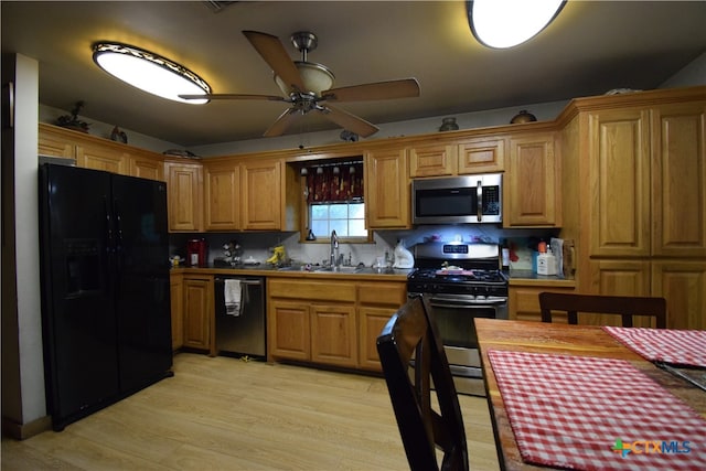 kitchen with light hardwood / wood-style floors, sink, black appliances, ceiling fan, and backsplash