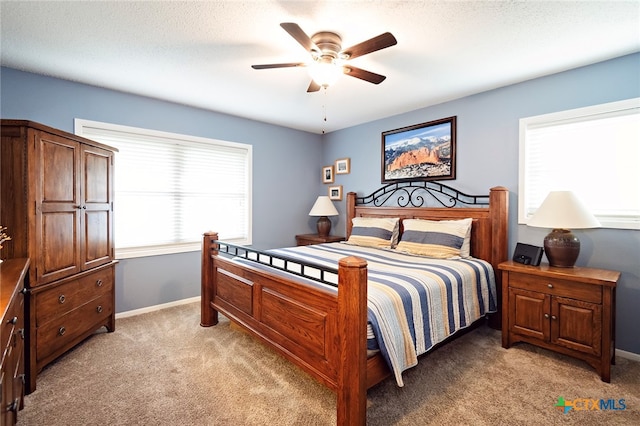 carpeted bedroom featuring a textured ceiling and ceiling fan