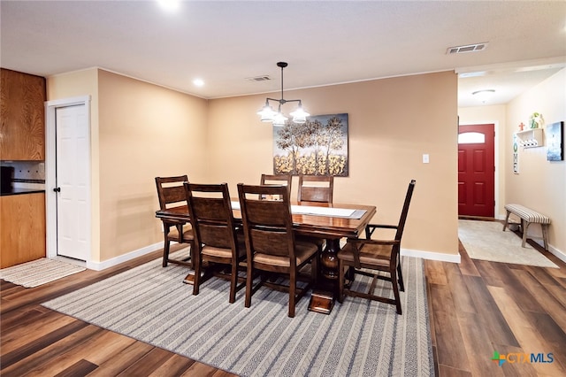 dining area with a notable chandelier and dark hardwood / wood-style floors