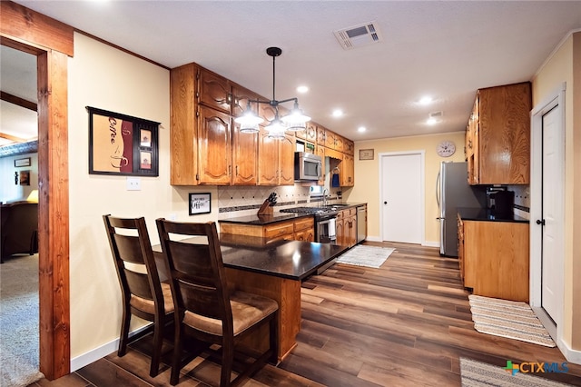 kitchen with stainless steel appliances, sink, decorative light fixtures, dark hardwood / wood-style flooring, and decorative backsplash