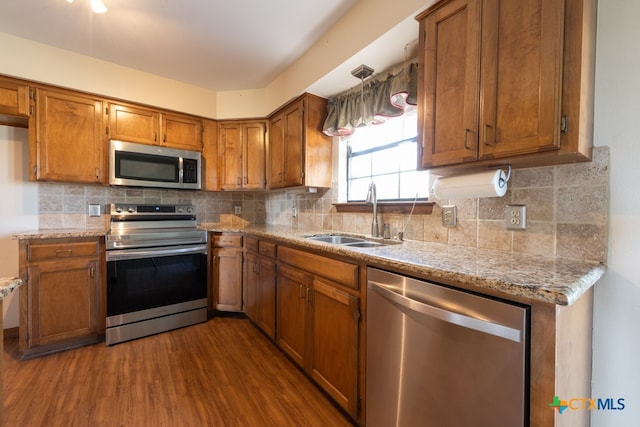 kitchen with sink, stainless steel appliances, tasteful backsplash, and dark wood-type flooring