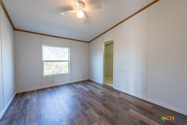 spare room featuring dark hardwood / wood-style flooring, ceiling fan, and crown molding