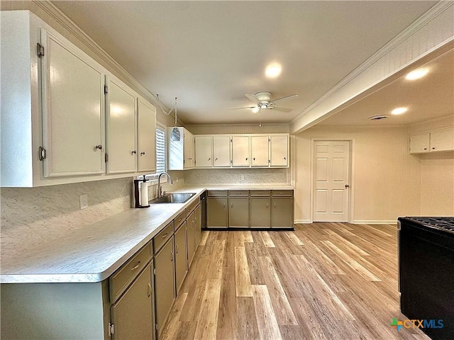 3301 Cypress St, Victoria, TX 77901 - kitchen with a sink, light wood-style floors, a ceiling fan, white cabinetry, and backsplash