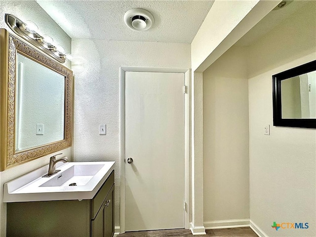 3301 Cypress St, Victoria, TX 77901 - bathroom featuring vanity, a textured ceiling, wood finished floors, and a textured wall