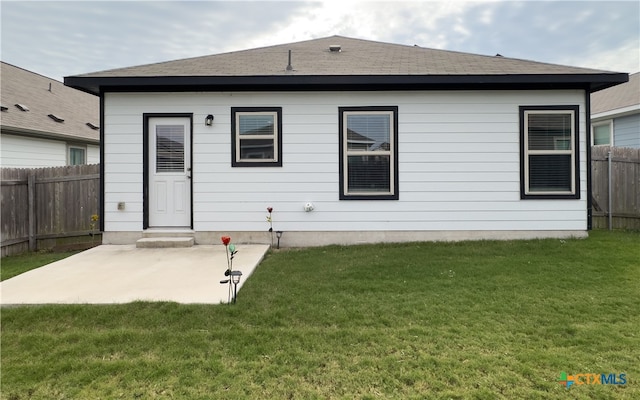 back of house featuring a patio area and a yard