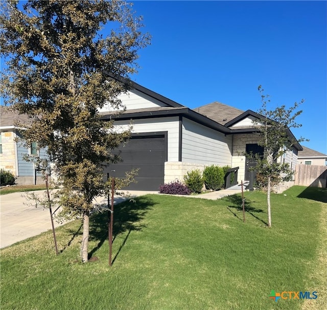 view of front of property featuring a front yard and a garage