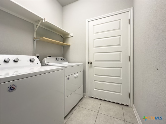 clothes washing area with separate washer and dryer and light tile patterned floors