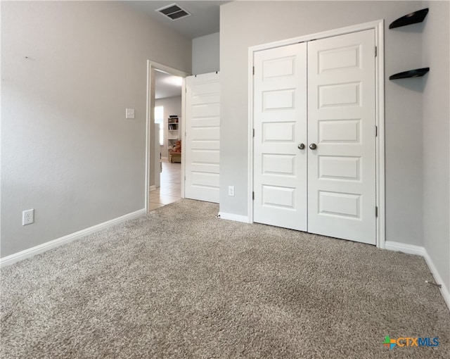 unfurnished bedroom with carpet and a closet