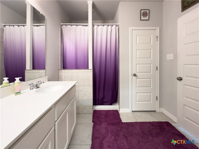 bathroom featuring tile patterned flooring, vanity, and curtained shower