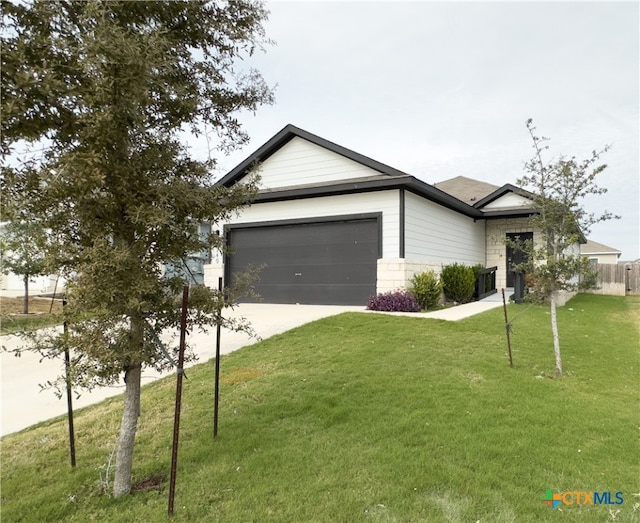 view of front of property featuring a front yard and a garage