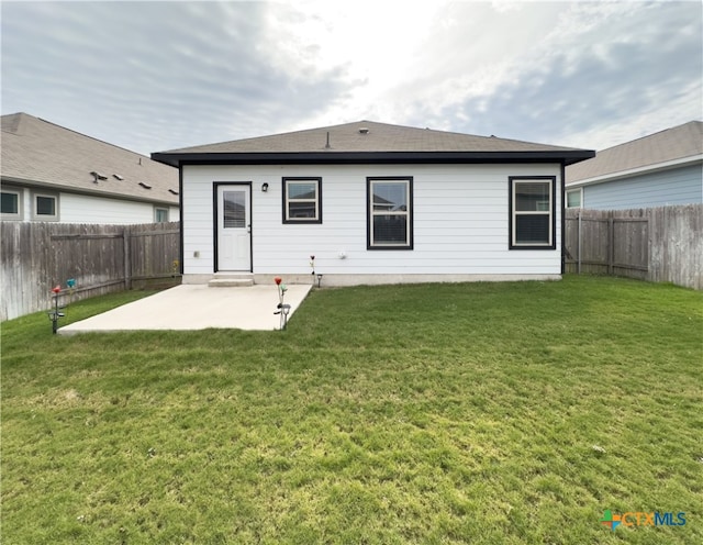 rear view of property with a yard and a patio area