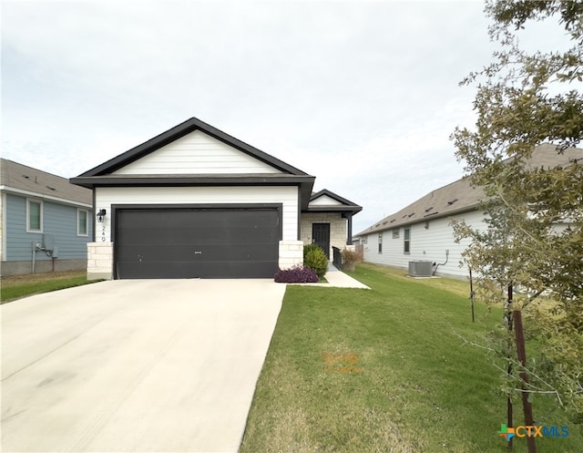 view of front of house with a garage, a front lawn, and central air condition unit