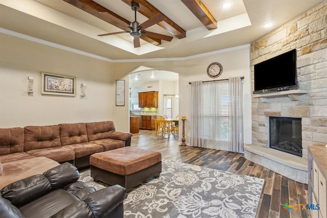 5907 Verde Dr, Killeen, TX 76549 - living room with a ceiling fan, a fireplace, dark wood-style floors, beamed ceiling, and arched walkways
