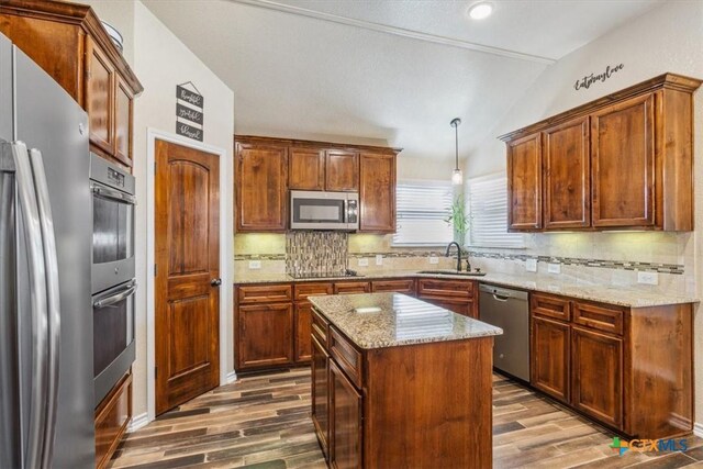5907 Verde Dr, Killeen, TX 76549 - kitchen with appliances with stainless steel finishes, a sink, vaulted ceiling, dark wood-style flooring, and tasteful backsplash