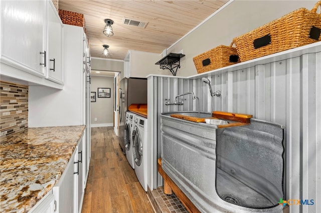 laundry room with laundry area, ornamental molding, wood ceiling, wood finished floors, and washer and dryer