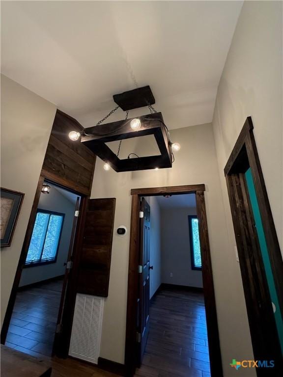 hall with plenty of natural light, wood finished floors, and baseboards