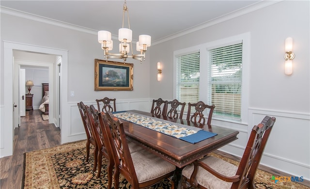 dining area featuring dark wood-type flooring, crown molding, and a notable chandelier