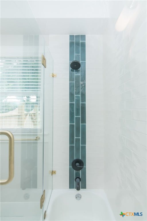 bathroom featuring combined bath / shower with glass door