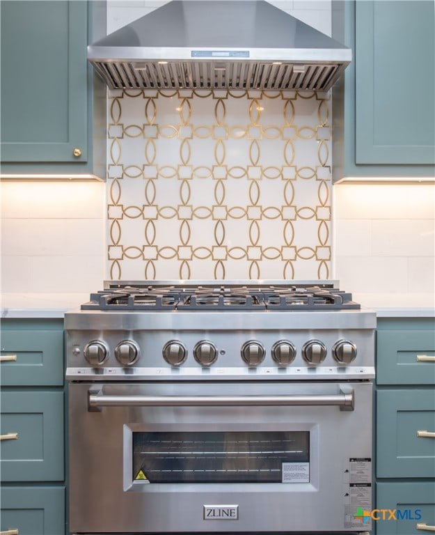 kitchen featuring high end stainless steel range oven, decorative backsplash, and wall chimney exhaust hood