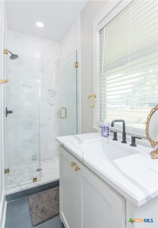 bathroom featuring tile patterned flooring, vanity, and a shower with shower door