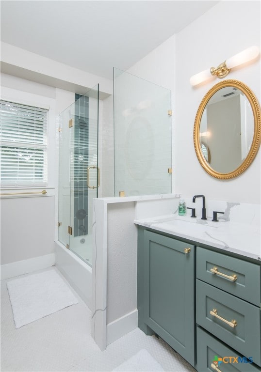 bathroom featuring shower / bath combination with glass door and vanity